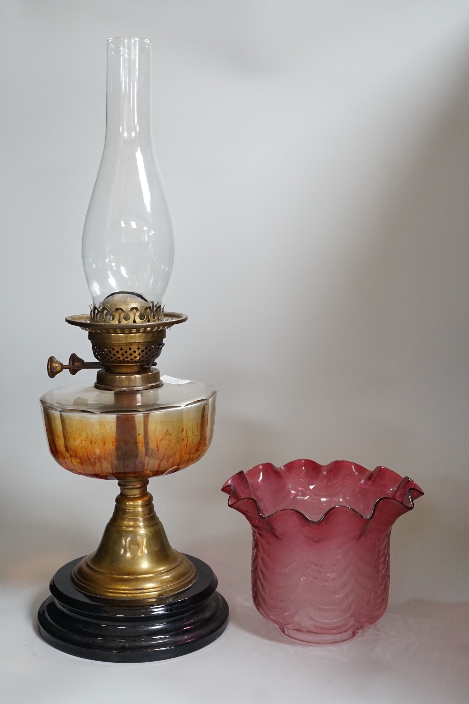A Victorian brass and cranberry glass oil lamp